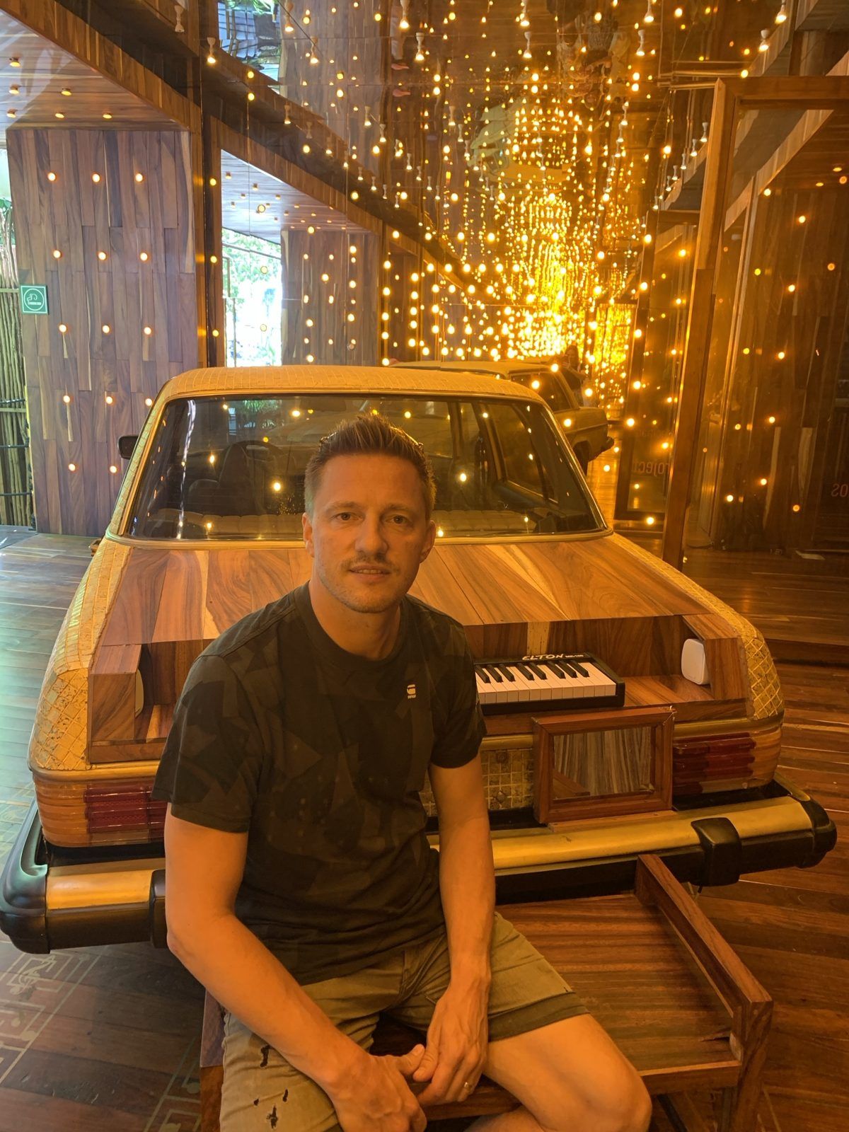 Jacco bij een auto onder warm licht