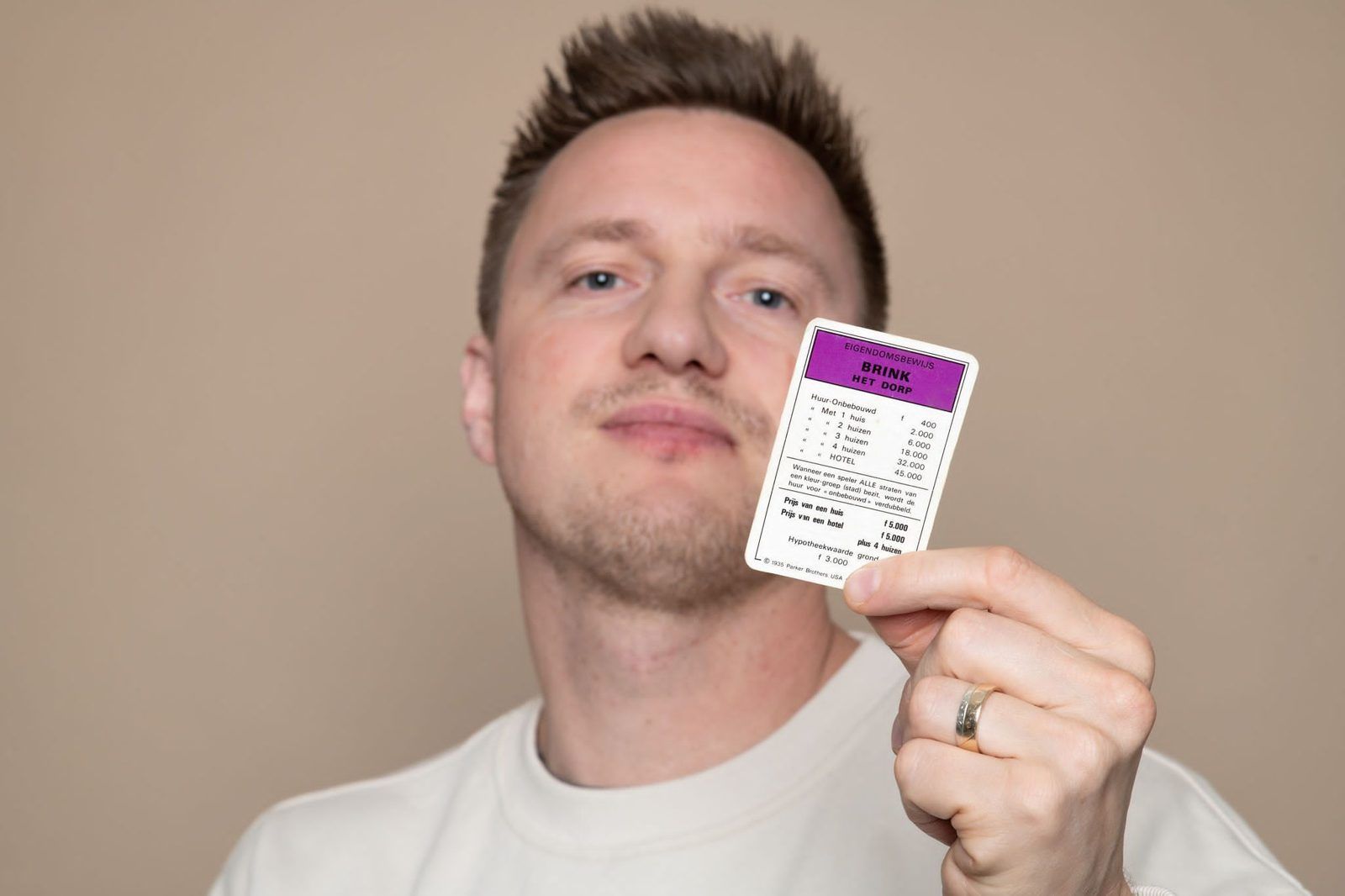 Jacco met een Monopolykaart met de straat Brink